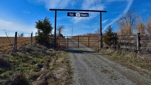 A rural entrance gate with a sign reading "High Country." - Serenity found in this large, lodge-style 4-bedroom house surrounded by nature (Goreville)
