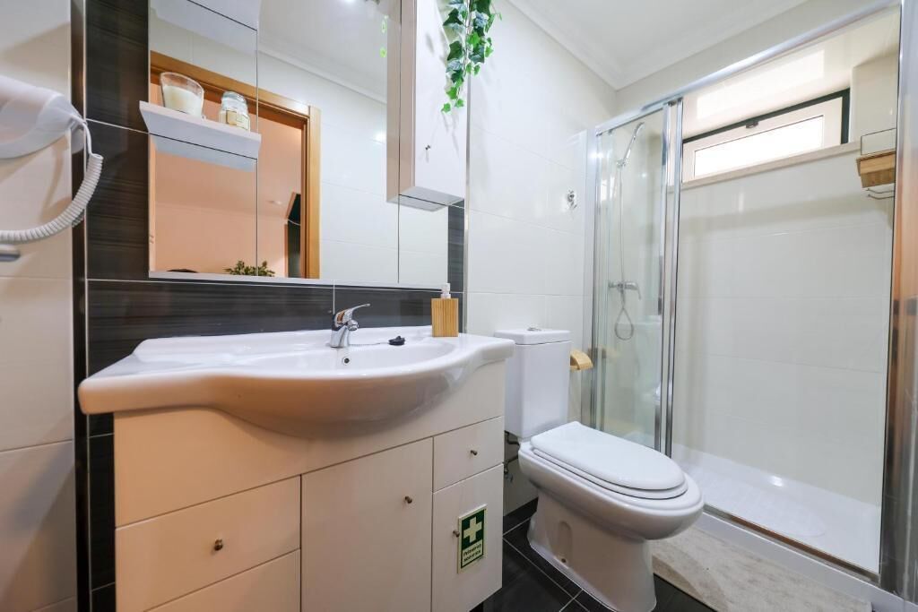 Ein modernes Badezimmer mit Waschbecken, Spiegel und Toilette.