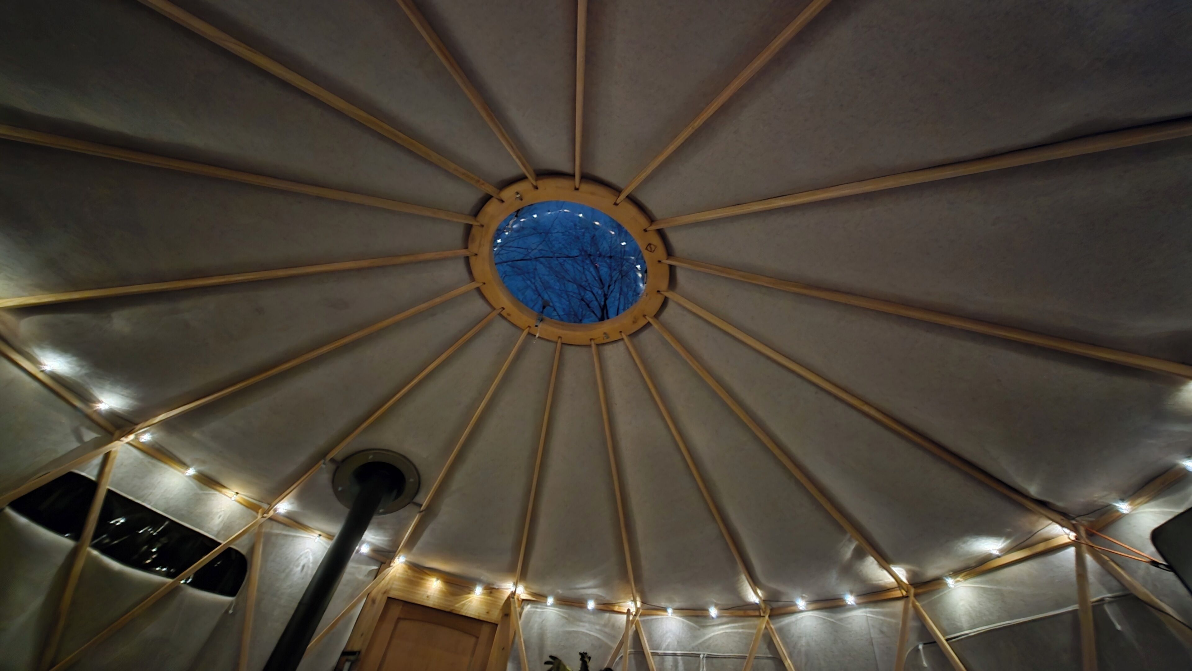 A circular room with a central skylight and wooden beams.
