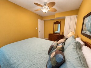 A bedroom with a bed, a ceiling fan, a dresser, and a mirror. - Saida III Condos - S3706 (South Padre Island)