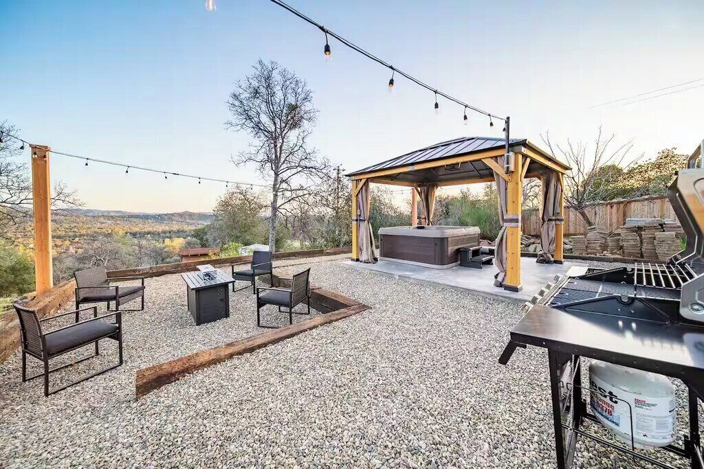 An outdoor patio with a grill, seating area, and a pergola.