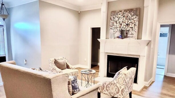 Un salon avec une cheminée, deux canapés, une table basse et un tapis à motifs.
