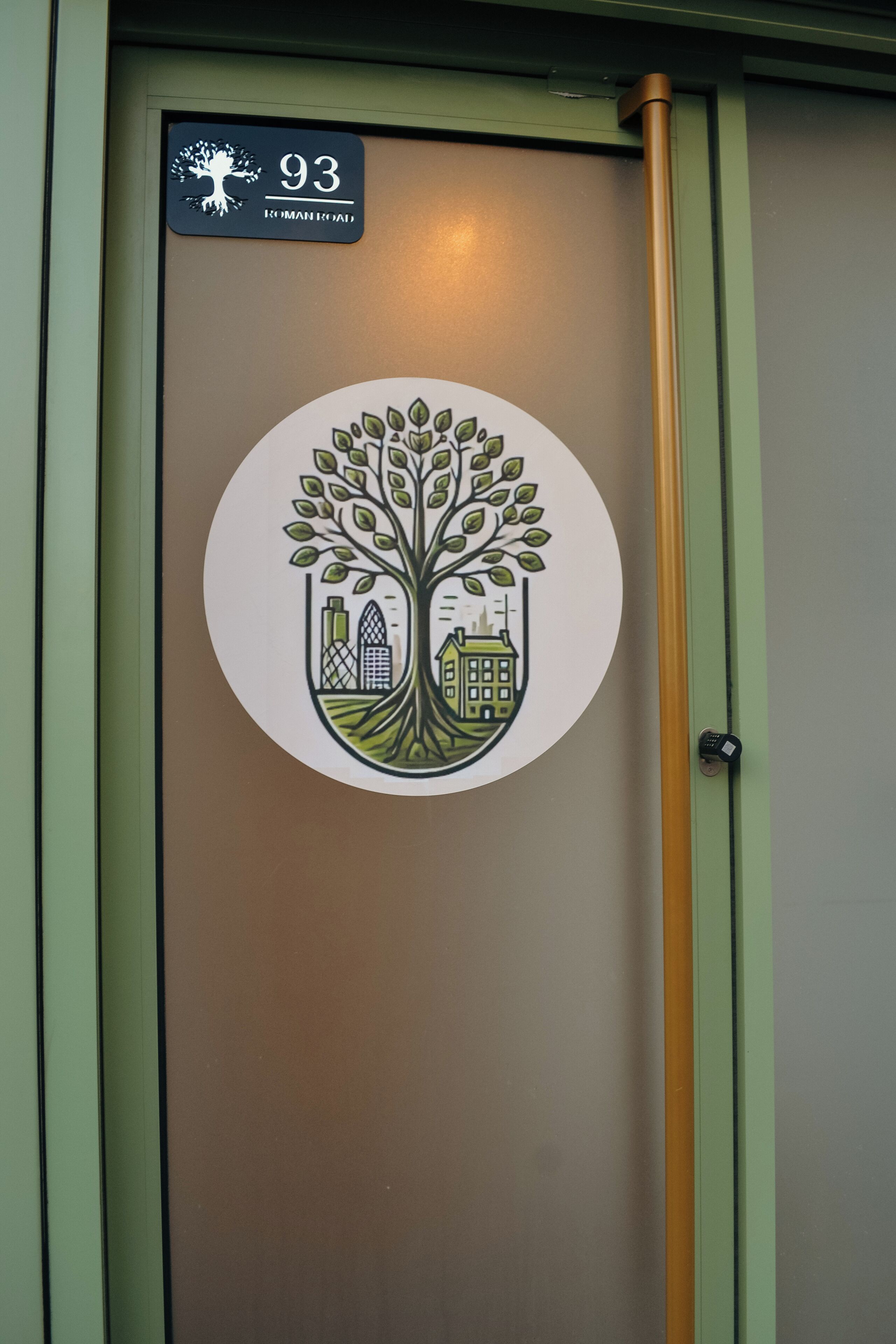 A door with a circular emblem featuring a tree and buildings, and a sign above it with the number 93.