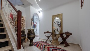 A staircase with a white railing, a patterned rug, and a mirror with a gold frame. - Dar Mawati (Marrakech)