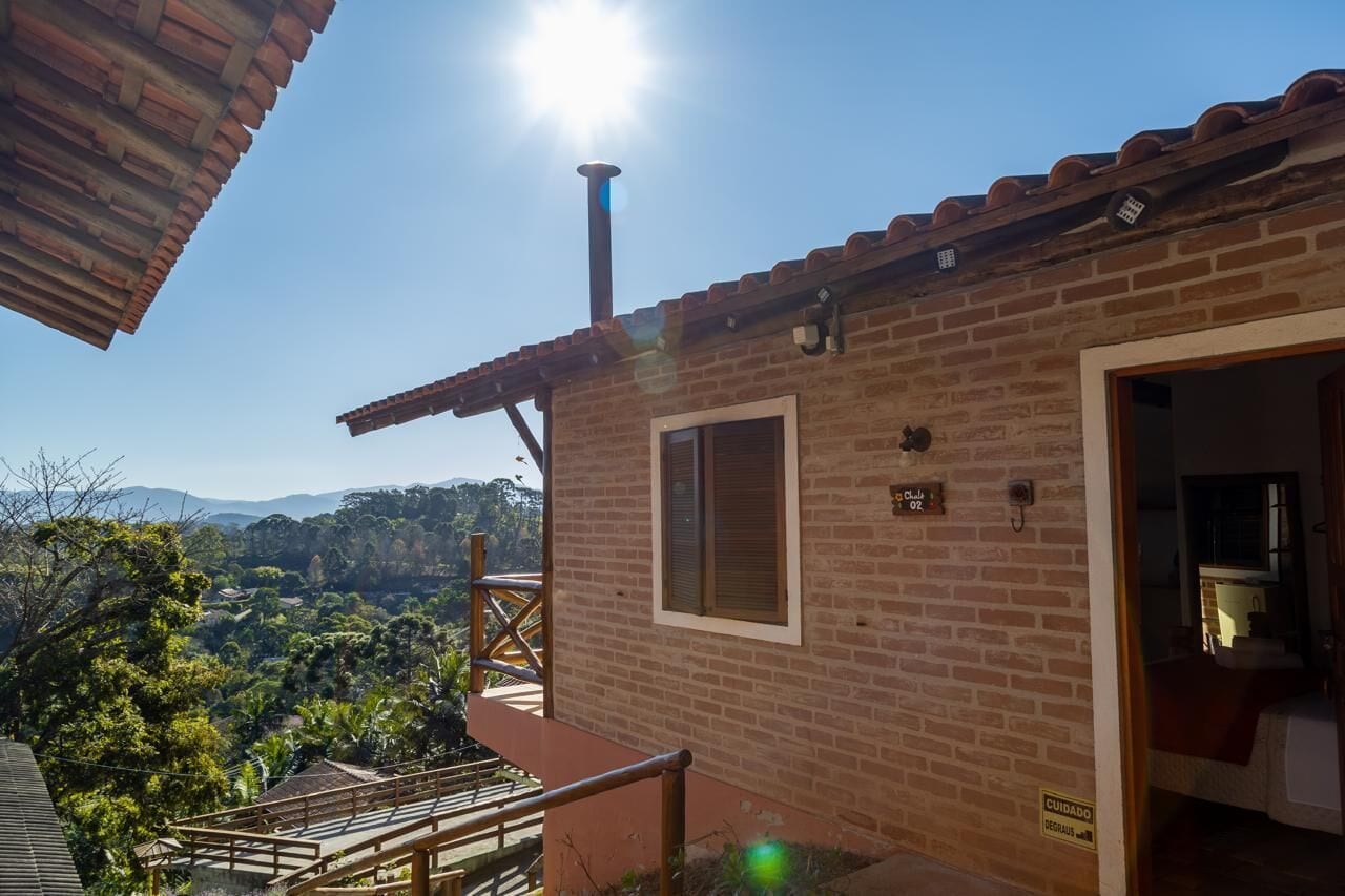 A brick building with a wooden balcony, a chimney, and a sign indicating room number 02.