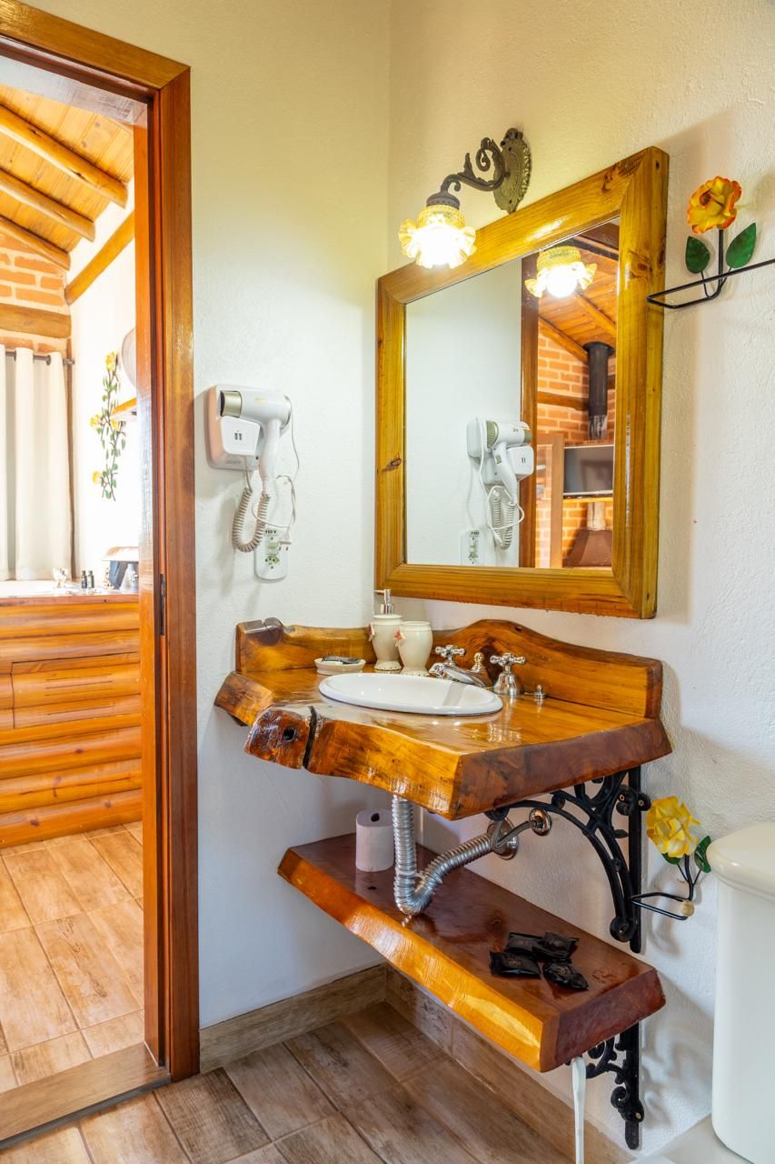 Un tocador de madera con lavabo, espejo y secador de pelo.
