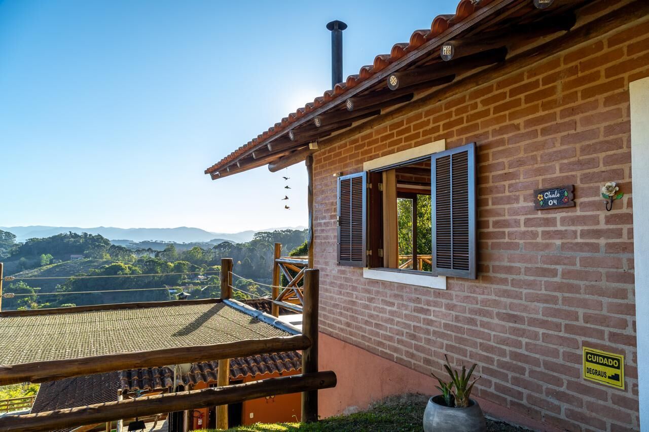 Un bâtiment en briques doté d’un balcon en bois qui offre une vue sur un paysage pittoresque.