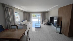 Una sala moderna con un sofá, una mesa de comedor y un televisor.