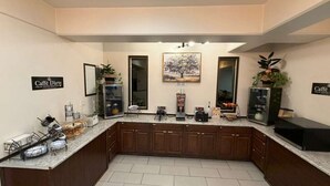 A modern kitchen with a central island, built-in cabinets, and a large window. - Spokane Boutique Hotel (Spokane)