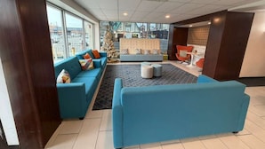 A modern lobby with a blue sofa set, a cushioned bench, and a small table. - Spokane Boutique Hotel (Spokane)