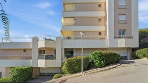 A multi-story residential building with balconies, a flat roof, and a clear sky. - Appartement Margot - Welkeys (Le Cannet)