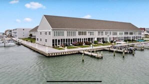 Un bâtiment situé au bord de l’eau, doté d’un grand quai qui s’avance dans l’eau, et entouré d’autres bâtiments.