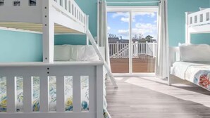 A room with bunk beds, a balcony, and a view of the outdoors. - Bayside Park Villa at Robin Drive (Ocean City)