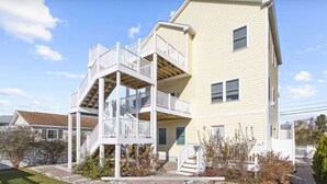 A two-story building with a central staircase and a balcony on the upper floor. - Bayside Park Villa at Robin Drive (Ocean City)