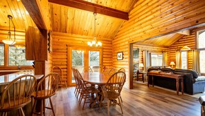 A log cabin interior with a dining area, kitchen, and living space. - The Log Cabin Where Memories are Made (Sunriver)
