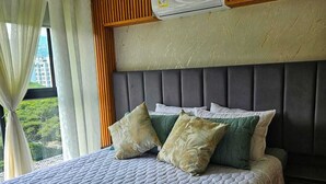 A bedroom with a large bed, a headboard, and a window with curtains. - Cozy 1-bedroom apartment with AC in tranquil Cali (Cali)