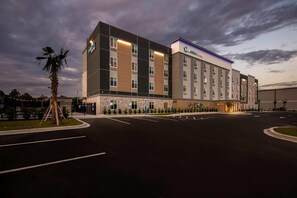 A hotel with a modern design, multiple floors, and a parking lot. - Everhome Suites Panama City Beach - 30A (Panama City Beach)