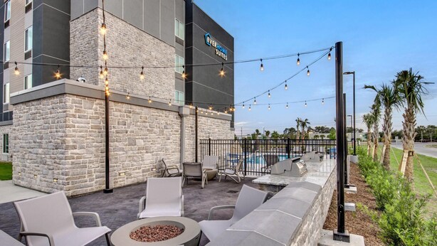 A hotel with outdoor seating, a pool, and string lights.