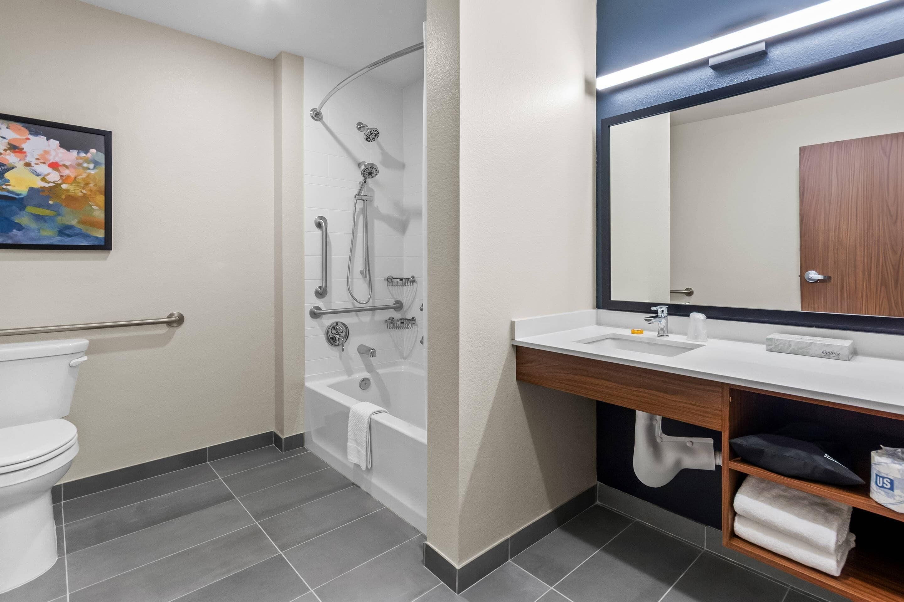 A modern bathroom with a toilet, shower, and sink.
