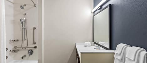 A modern bathroom with a bathtub, shower, and vanity.