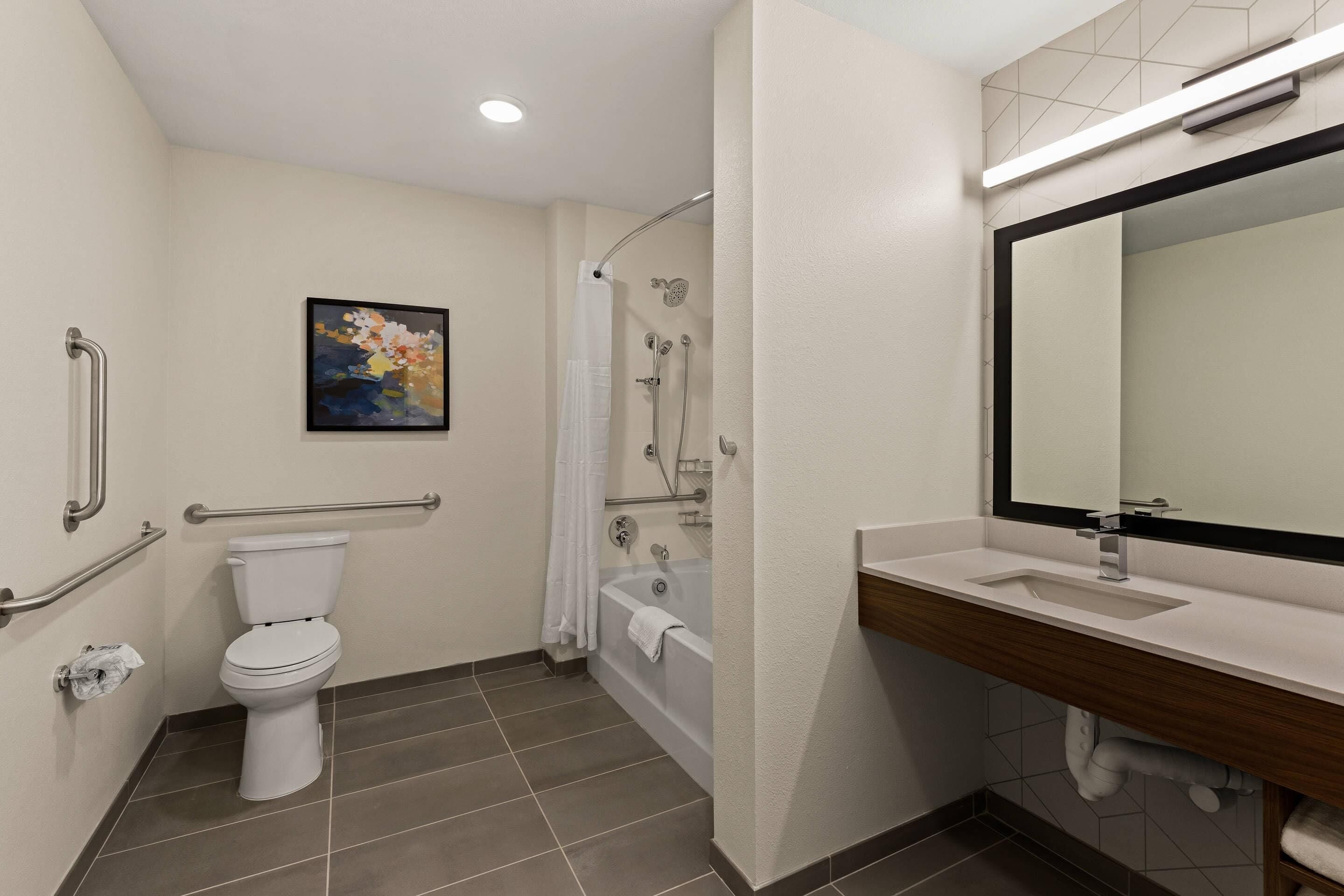 A bathroom with a toilet, shower, and sink.