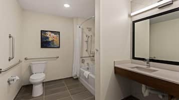 A bathroom with a toilet, shower, and sink.