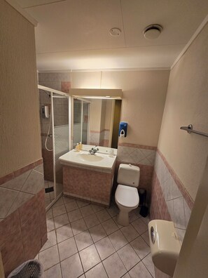 A bathroom with a shower, toilet, sink, and hand dryer. - Hotell Våler-Elverum-flisa-kirkenær (Våler)
