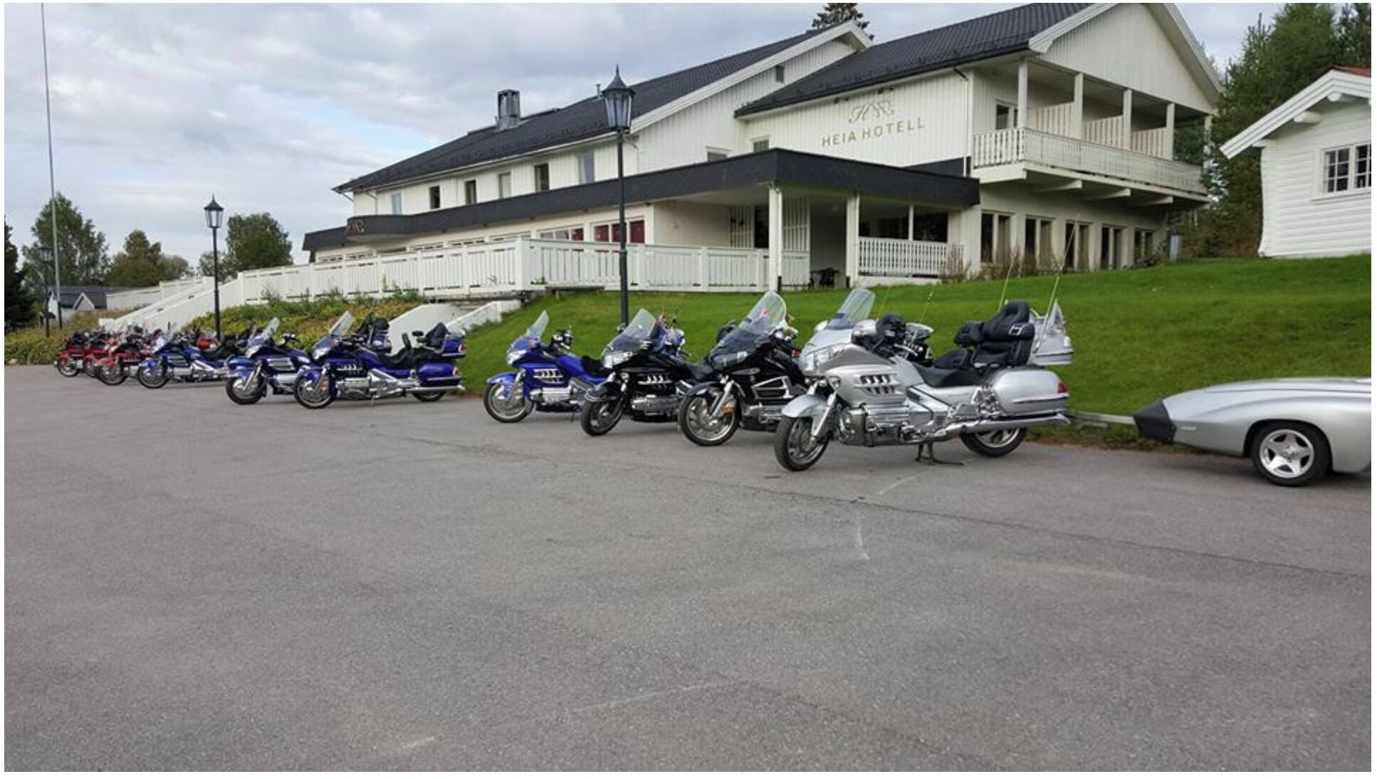 A hotel with a covered outdoor area and a row of parked motorcycles.