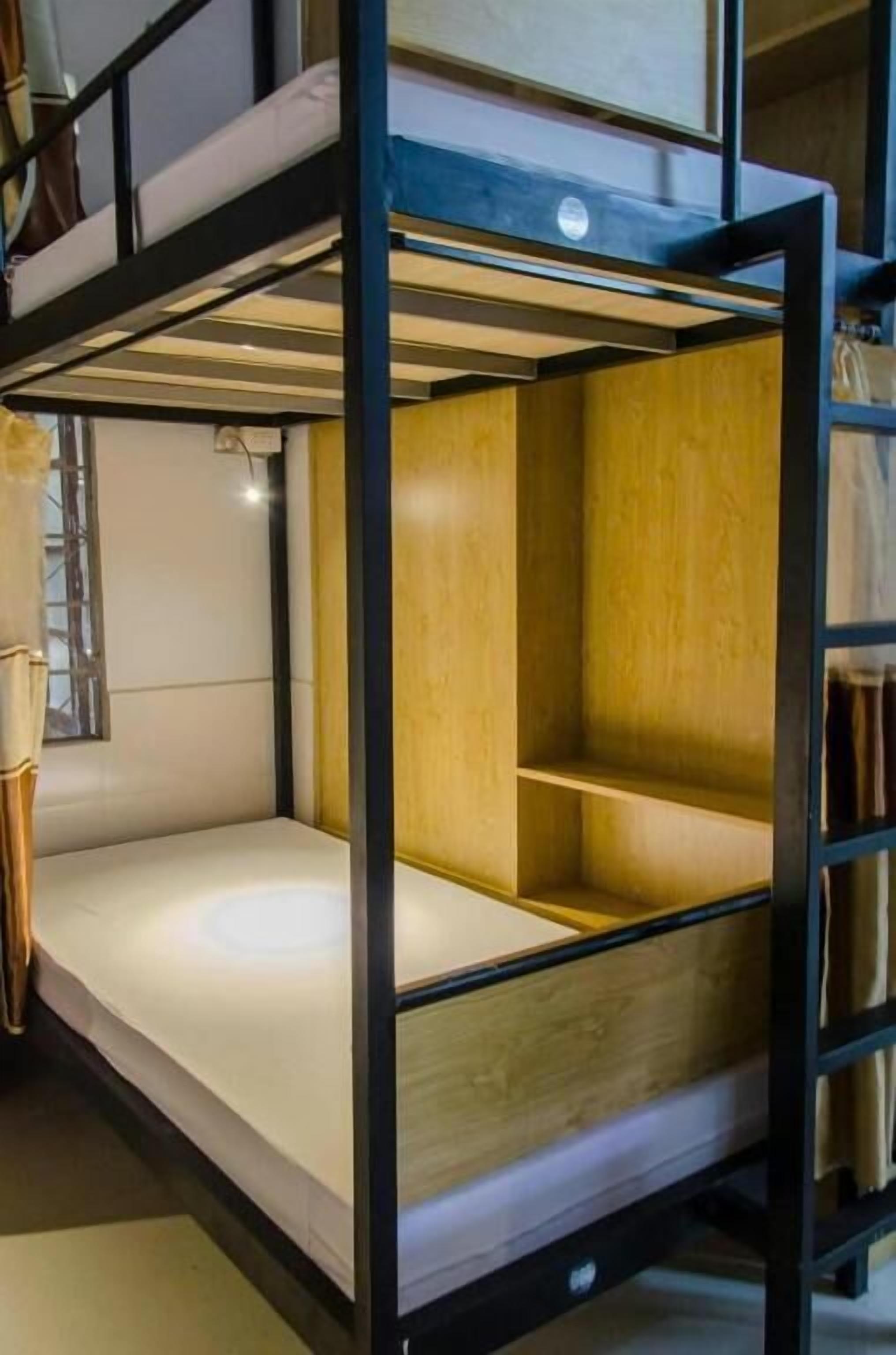 Un lit superposé avec une structure en bois et un matelas blanc.