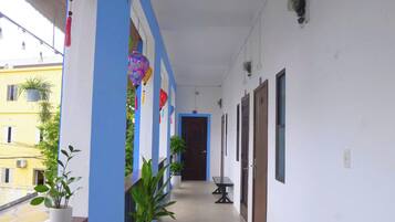 A corridor with a blue and white color scheme, potted plants, and a sign indicating an exit.