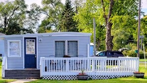 En etplans mobilhome med veranda og hegnede terrasse.