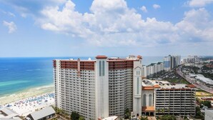 Ein Hochhaus-Hotel mit mehreren Balkonen mit Blick auf Strand und Meer.