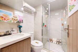 Un bagno moderno con doccia in vetro, un lavandino bianco e un water.