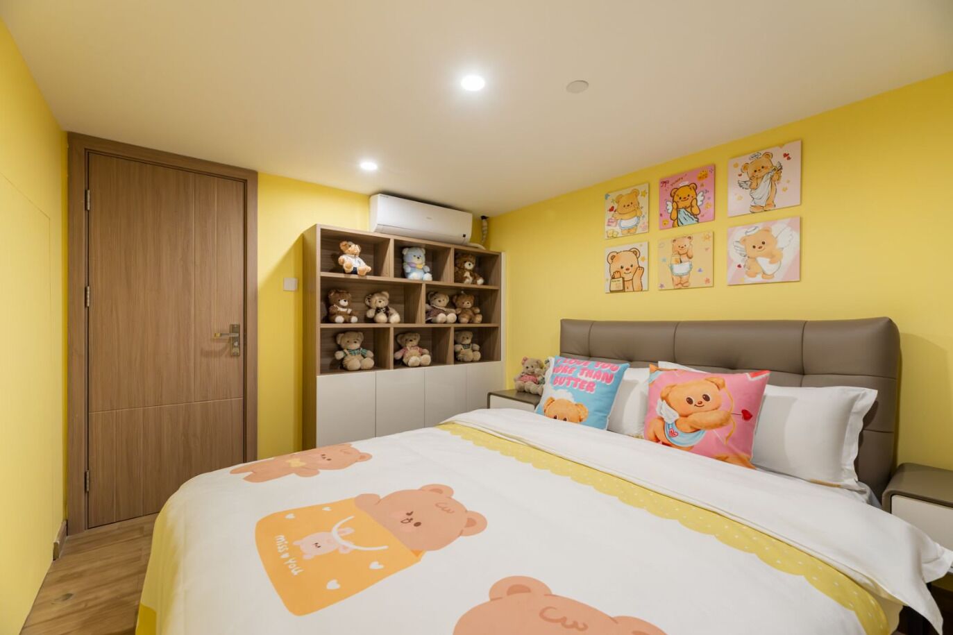 A bedroom with a bed, a wardrobe, a shelf with stuffed animals, and wall decorations.
