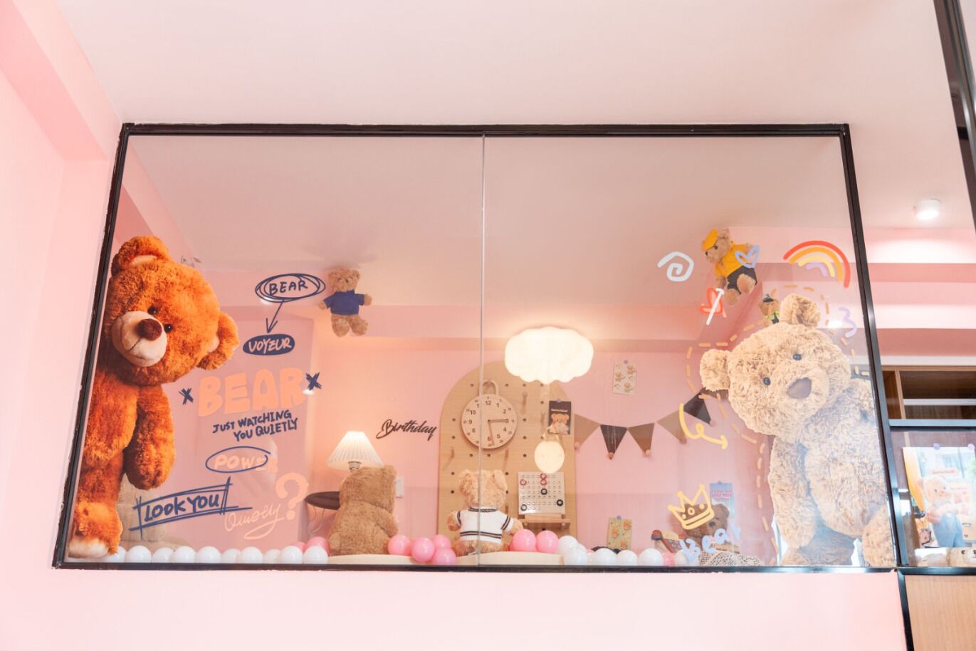 A window display with various teddy bears and a clock.