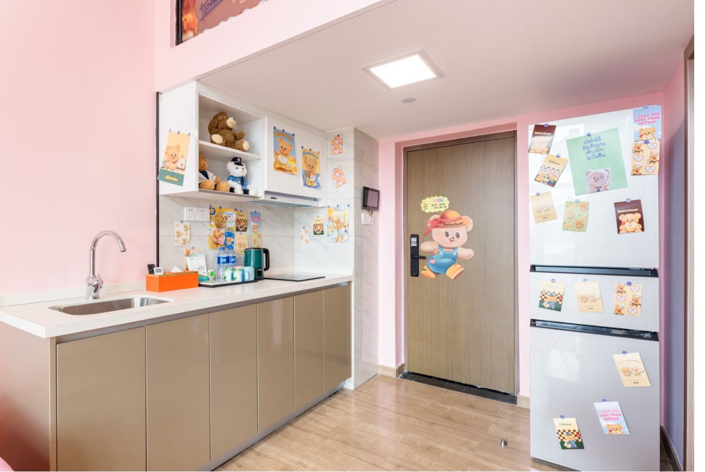 A modern kitchen with a sink, cabinets, and a refrigerator adorned with children's stickers.