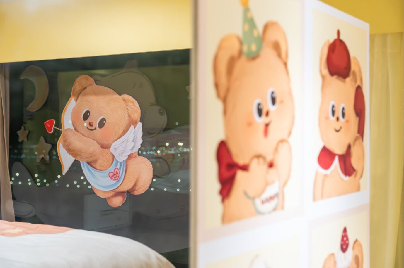 Un oso de peluche con alas de ángel y una pajarita con forma de corazón, colgado en una pared con vista a una ventana.