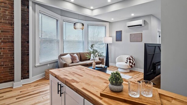 Un salon moderne avec une table basse en bois, un canapé et un téléviseur.