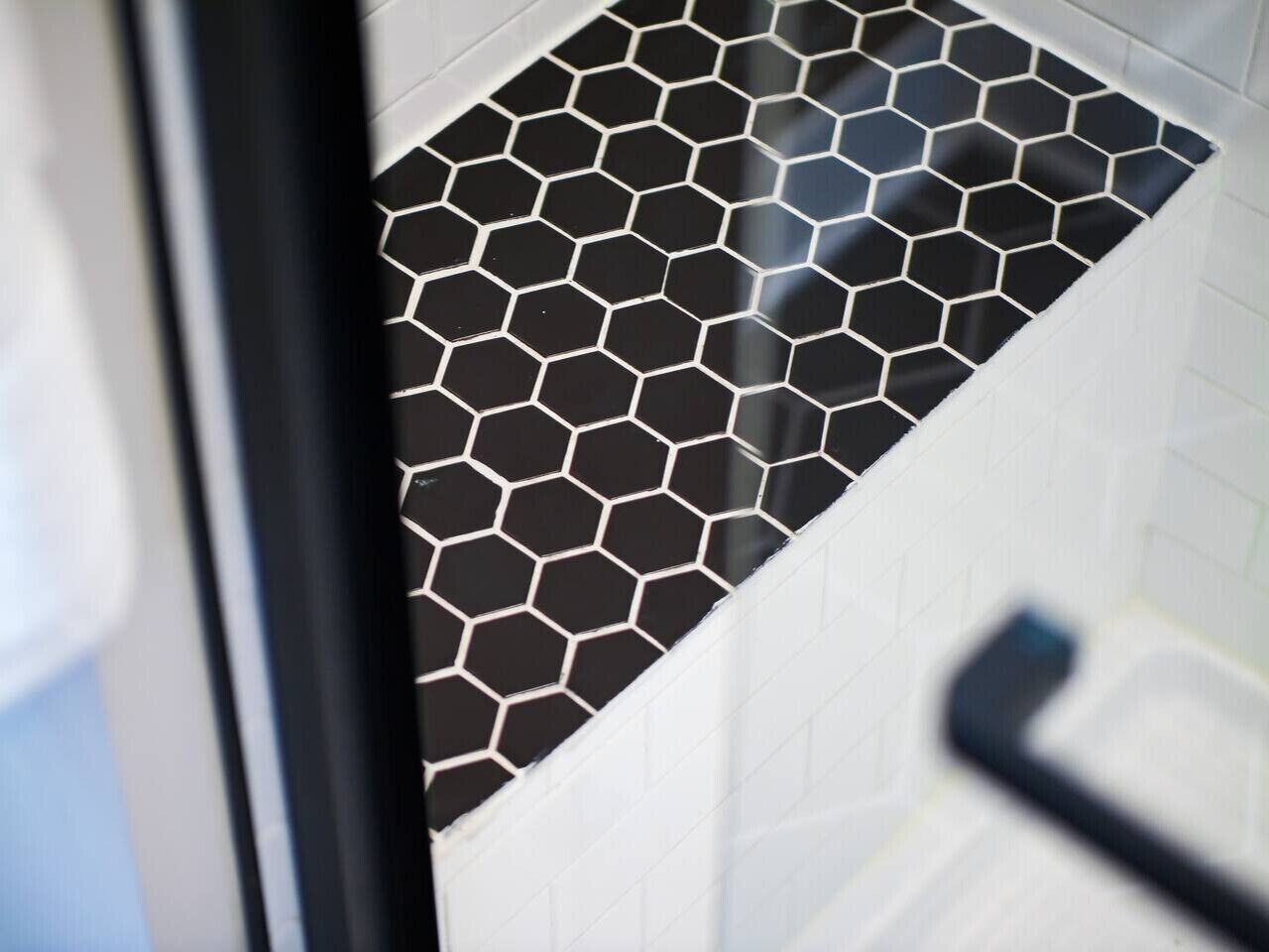 A bathroom with a black and white hexagonal tile pattern on the floor.
