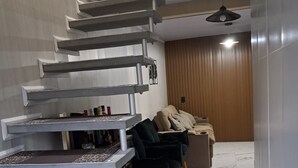 Et moderne interiør med en spiraltrappe, en sofa og en væg af træpaneler.