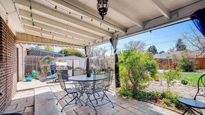 A covered patio with a grill, outdoor seating, and a view of the backyard. - Furnished monthly rental Near Downtown Denver (Denver)