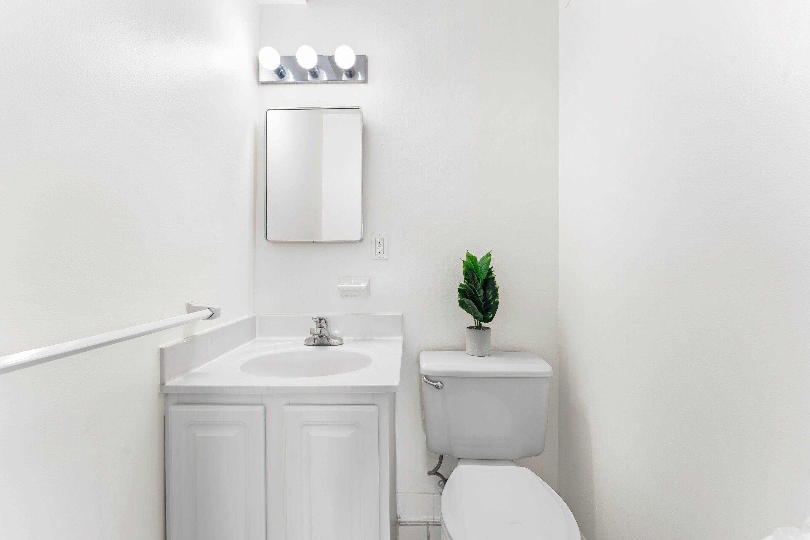 Ein helles Badezimmer mit Waschbecken, Spiegel und Toilette.