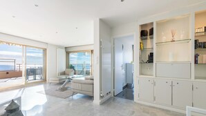 A spacious living area with a balcony, a seating area, and a kitchen. - 2-Br Panoramic Sea View & Beach Access (Cannes)
