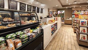 Een bakkerijafdeling met diverse gebakken producten en een bedieningsbalie met belegde broodjes en salades.