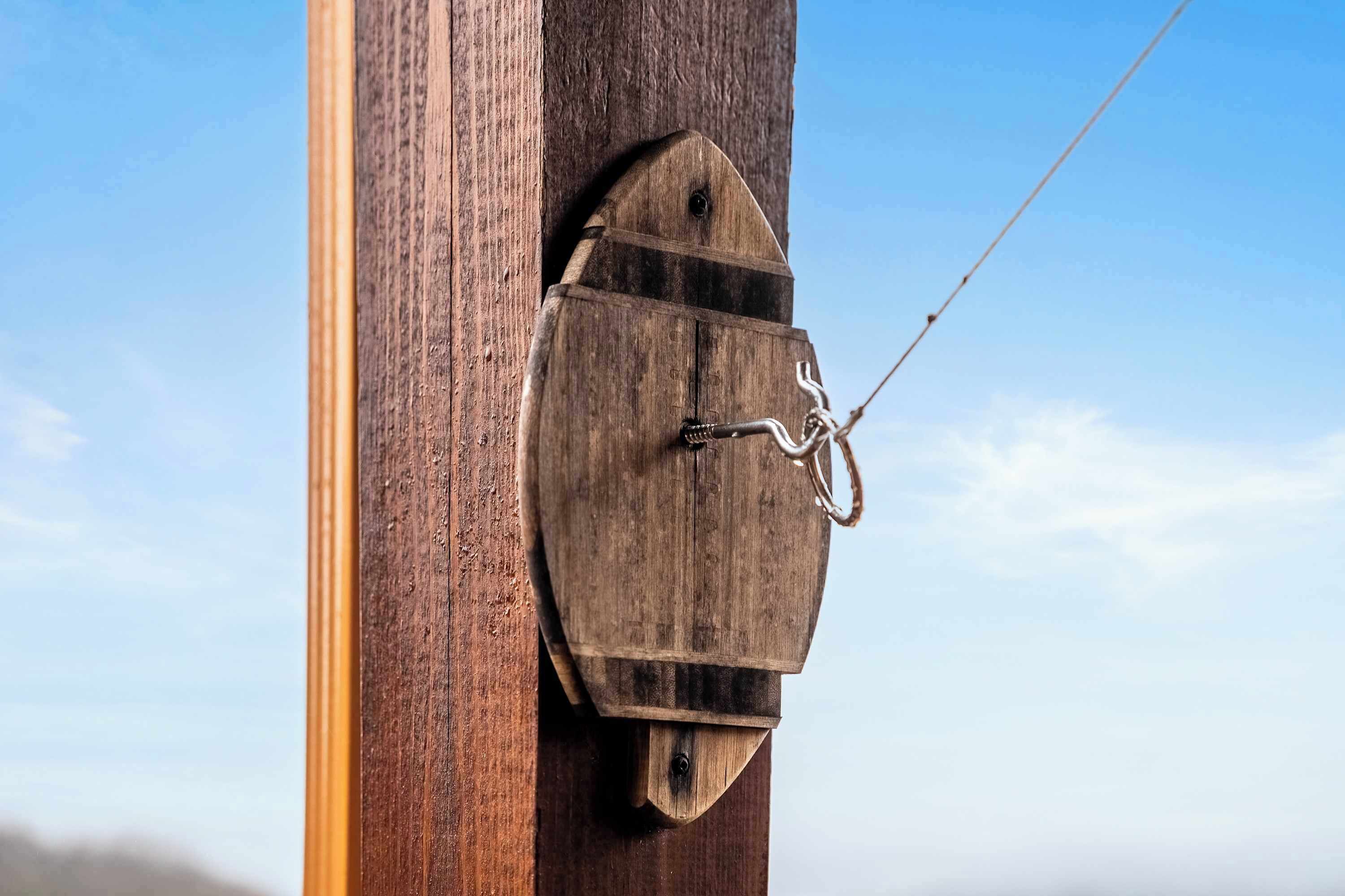 A wooden structure attached to a pole with a metal wire.