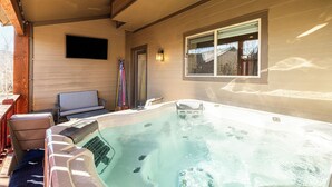 A hot tub area with a wooden deck, a bench, and a window overlooking a backyard. - Year-round Altitude Adjustment, Private Hot Tub, Community Amenities, Walk to Restaurants and more! (Park City)
