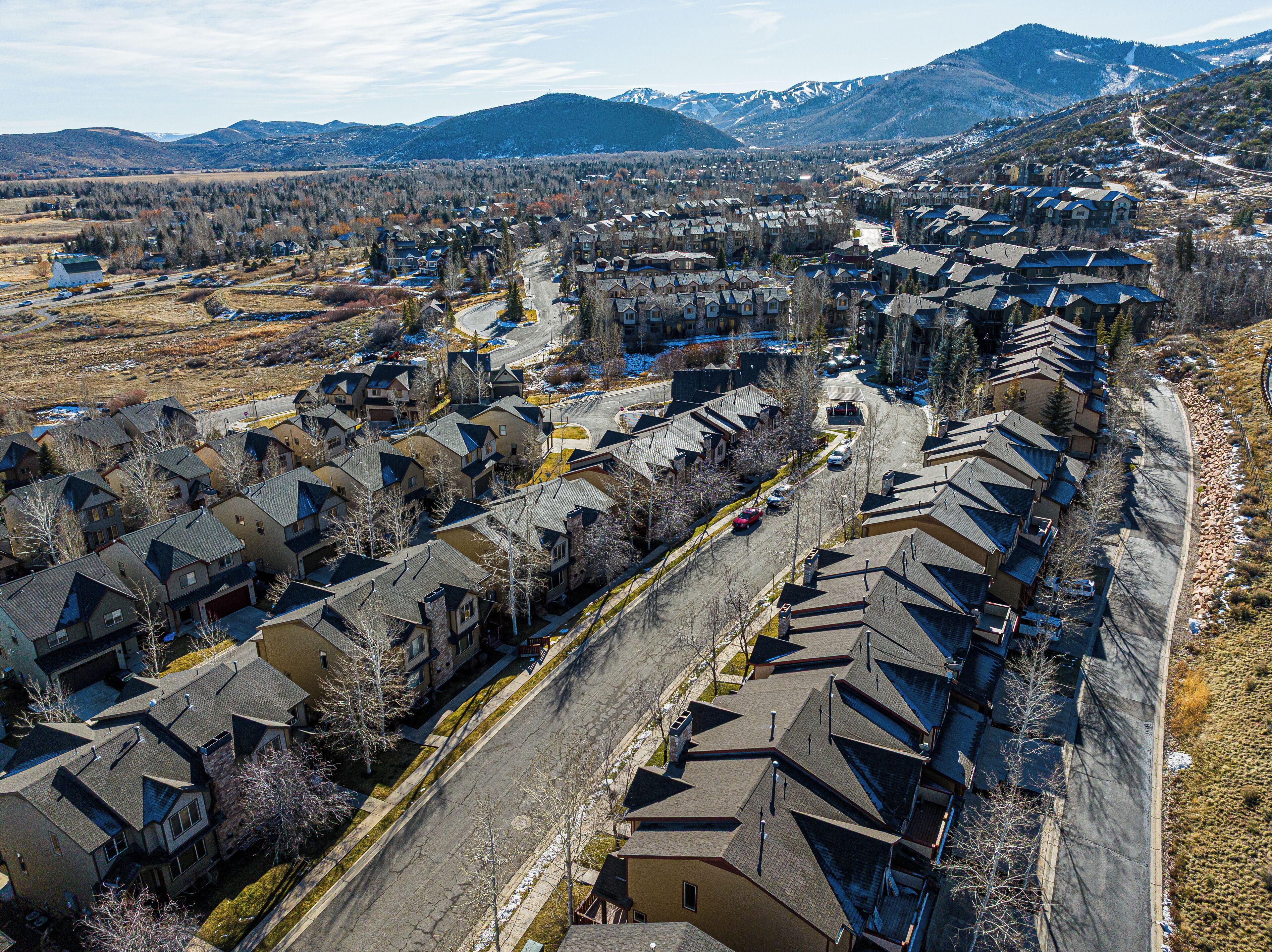 A residential area with houses, roads, and a mountainous backdrop.