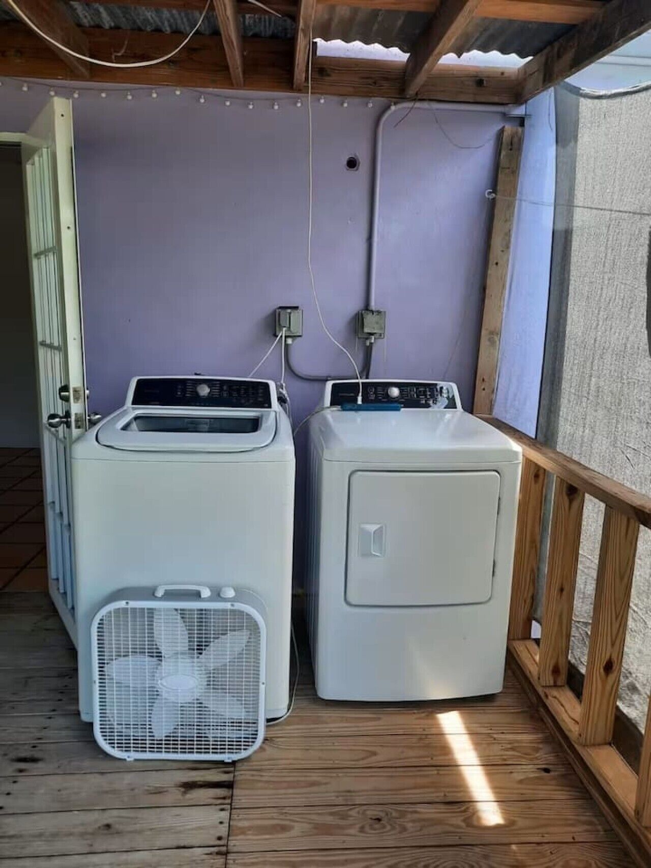 A laundry room with two washing machines and a drying rack.