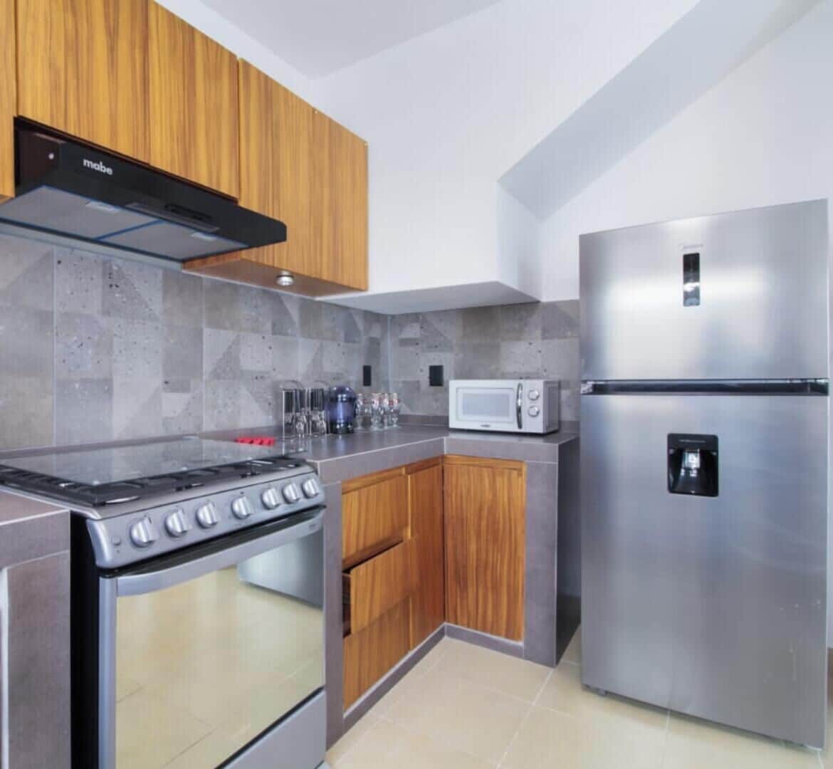 A modern kitchen with a gas stove, microwave, and stainless steel refrigerator.