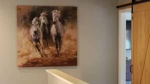A staircase with a painting of horses on the wall above it. - Reed's Ranch House In Star (Star)